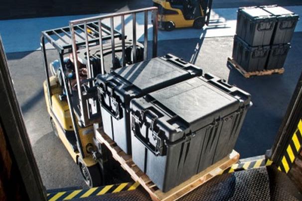 forklift operator loading transit cases into trailer